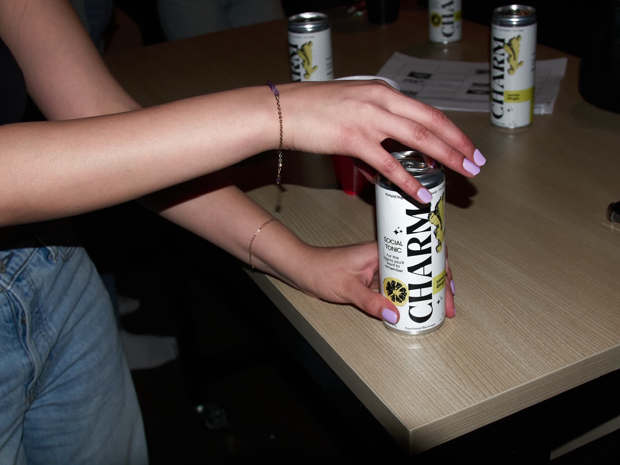 Charm social tonic can held in hand