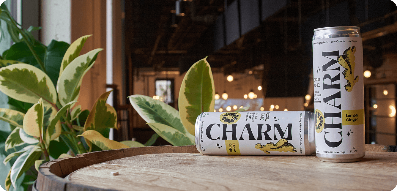 Charm Social Tonic cans on wooden barrel with plants