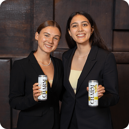 Charm founders Della Daml and Josie Miller holding cans